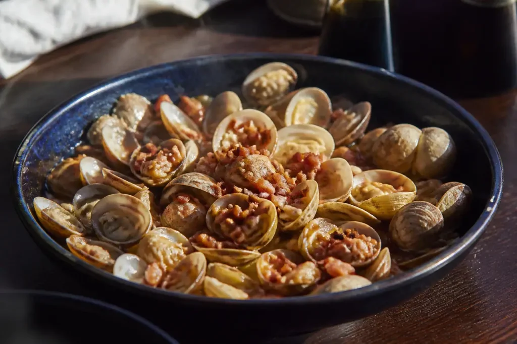 Assiette fumante coquillages lardons croustillants