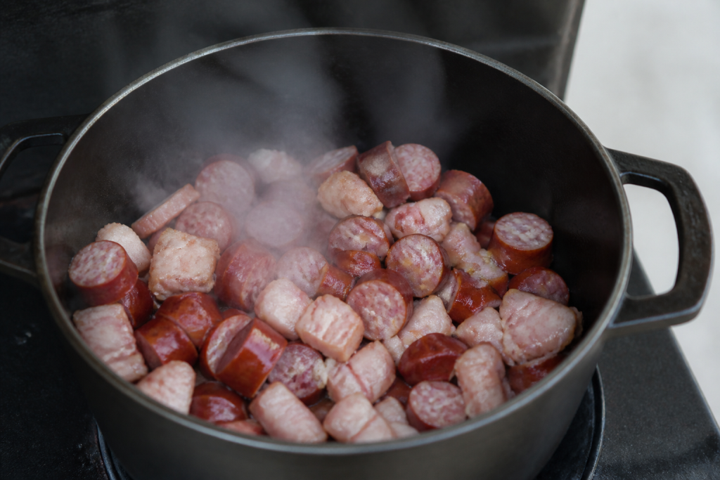 Cubes lard porc et saucisses dans faitout fumant