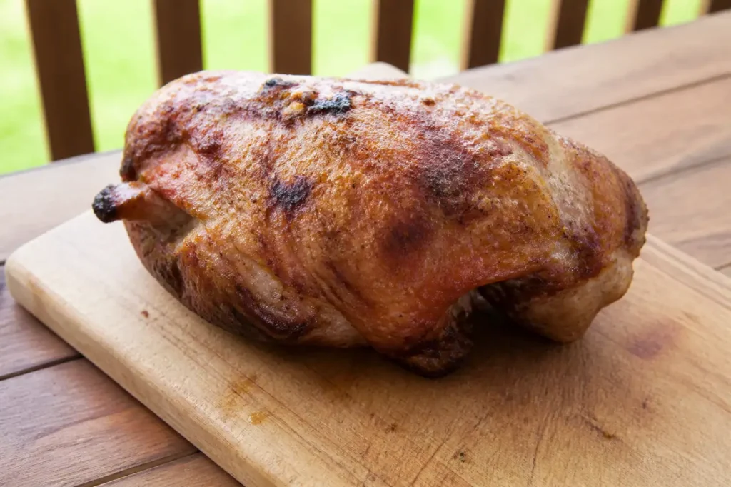 Palette de porc doree reposant sur planche en bois
