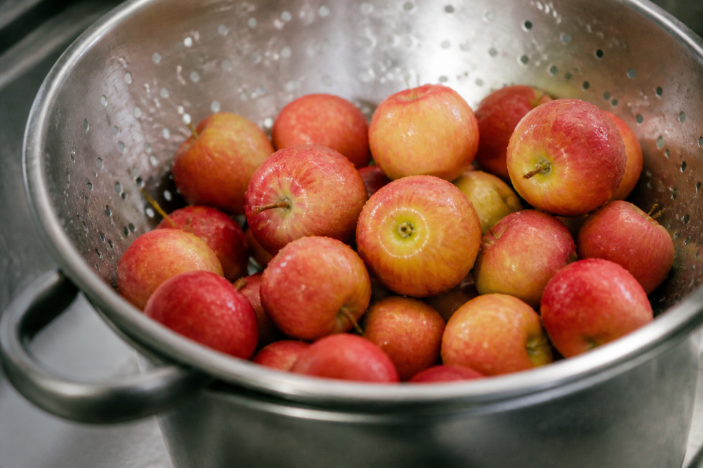 Petites pommes mouillees dans passoire apres lavage rapide